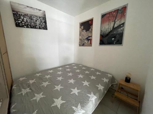 - une chambre avec un lit et trois photos sur le mur dans l'établissement Le Cheret, à Nice