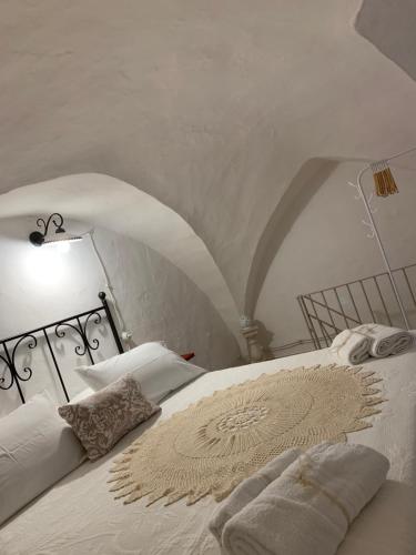 a white bed with a lamp and pillows on it at Casa Dante - Holiday House in Fasano