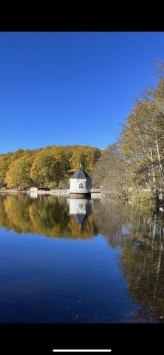 a house on a lake with its reflection in the water at Ruhige Ferienwohnung im Saarland in Schiffweiler