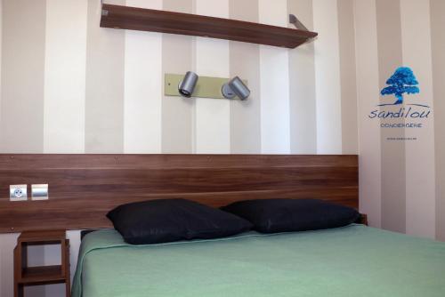 a bed with two pillows on it in a room at Mobilhome « Destination de vacances» in Sigean