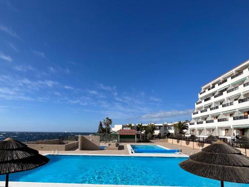 een resort met twee zwembaden en een groot gebouw bij Aloha - Costa del Silencio in Arona