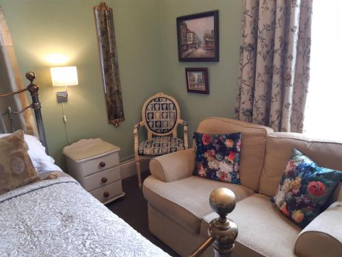 a bedroom with a bed and a couch and a chair at Holywell House in Loughborough