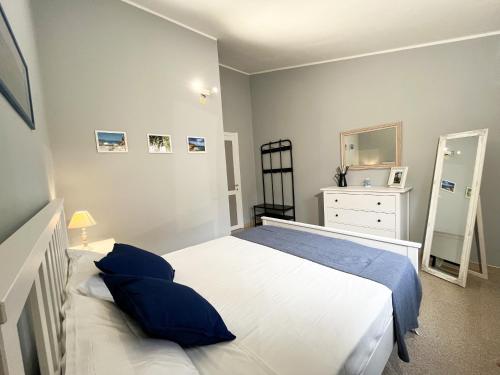 a bedroom with a white bed with blue pillows at Villa SALMAGI - Sardegna in Terra Mala