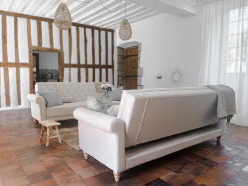 un soggiorno con 2 divani bianchi e un tavolo di Maison de charme, grand SPA JACUZZI, WIFI Fibre & Netflix 