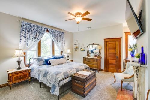 a bedroom with a bed and a ceiling fan at Central Chanute Historic Home with Porch! in Chanute
