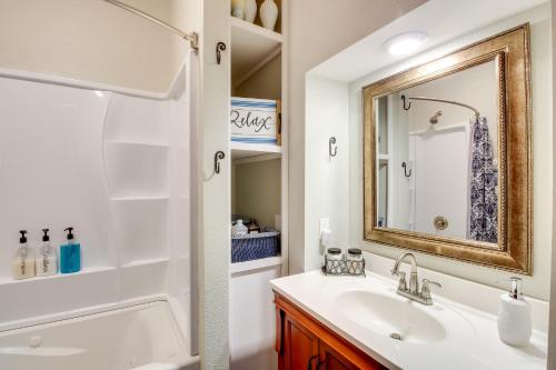 a bathroom with a sink and a mirror at Central Chanute Historic Home with Porch! in Chanute