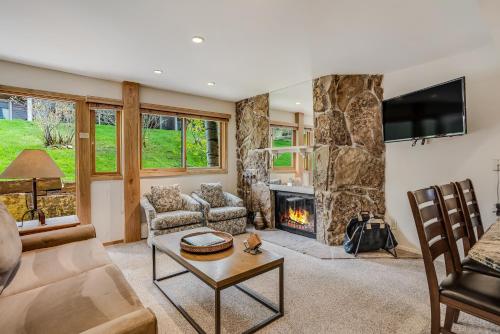 a living room with a fireplace and a tv at Laurelwood Condominiums 403 in Snowmass Village