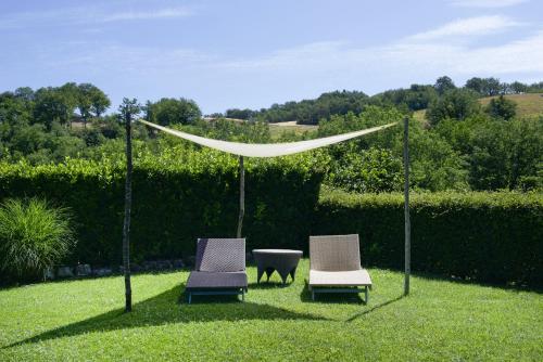 2 Stühle und ein Tisch im Gras mit einem Zelt in der Unterkunft Coroncina in Belforte del Chienti