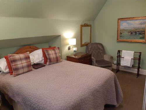a bedroom with a large bed and a chair at Holywell House in Loughborough