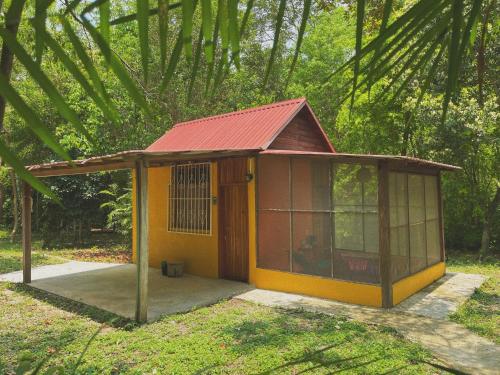 a small house with a red roof in a forest at Ecohabitat in Xpujil