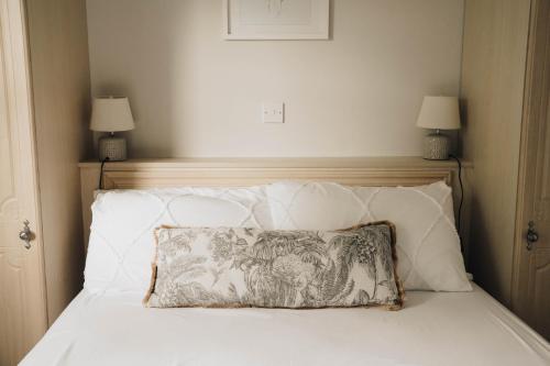 a bed with a pillow on it with two lamps at Donegal Estuary Holiday Homes in Donegal