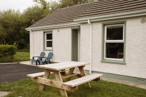 a wooden picnic table in front of a house at Donegal Estuary Holiday Homes in Donegal