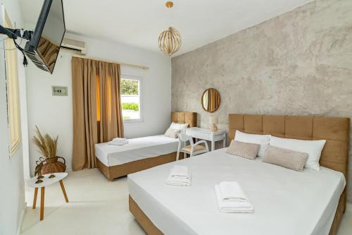 Cette chambre comprend 2 lits et une fenêtre. dans l'établissement Theo Bungalows Boutique Hotel, à Kriopigi