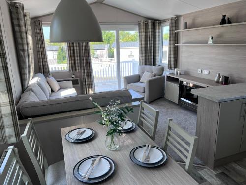 a living room with a table and chairs and a couch at Porthcurno 4, Silverbow Country Park in Perranzabuloe