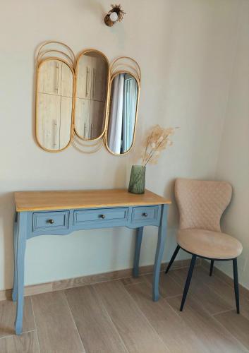 a dressing table with a chair and two mirrors at Electra Villa & Pool Studios in Gaios