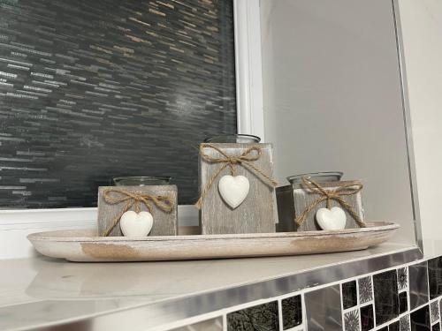 a shelf with three candles with hearts in them at Luxury Holiday Home in Manchester