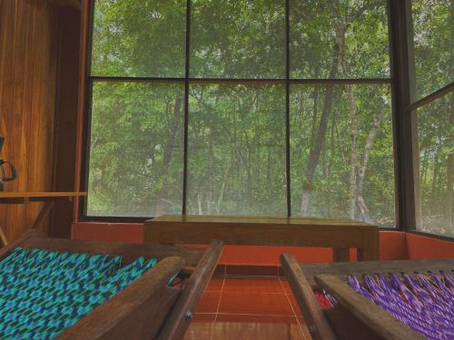 a room with two benches and a large window at Ecohabitat in Xpujil