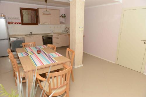 a kitchen with a wooden table and chairs in a room at Villa MIA Sozopol in Sozopol