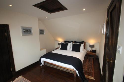 sypialnia z łóżkiem z czarno-białymi poduszkami w obiekcie Easdale Cottage w mieście Ellanbeich