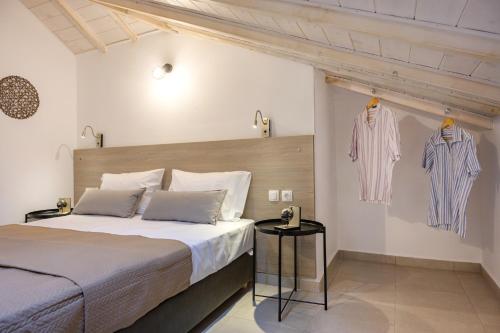 a bedroom with a bed and two shirts hanging on the wall at Zeyia in Ierissos