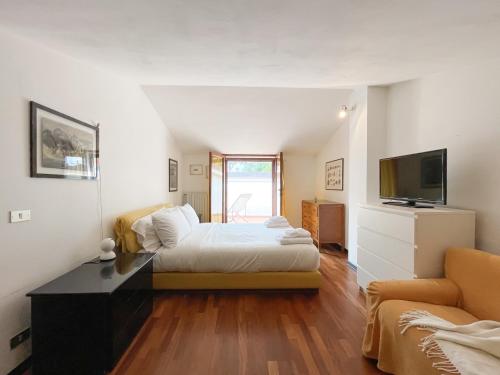 um quarto com uma cama, uma televisão e um sofá em Villetta Vinci em Pietrasanta