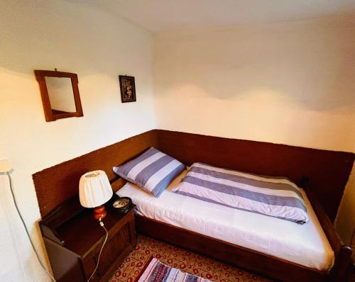 Dormitorio pequeño con cama y lámpara en Oáza klidu, en Hrádek