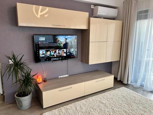 トゥルグ・ムレシュにあるTravel Apartmentの壁に薄型テレビが取り付けられたリビングルーム
