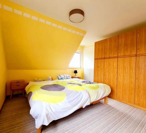 a bedroom with a large bed with a yellow wall at Wunderschöne Wohnung in Bevern - Holzminden in Bevern