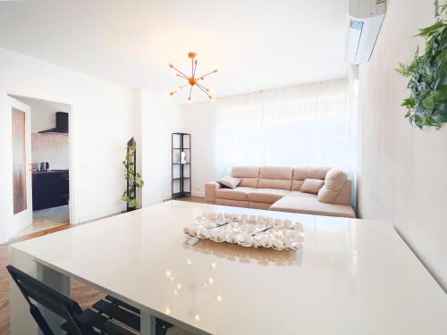 SuitesFlores - Bright and cozy apartment in Verona في فيرونا: غرفة معيشة مع طاولة بيضاء وأريكة