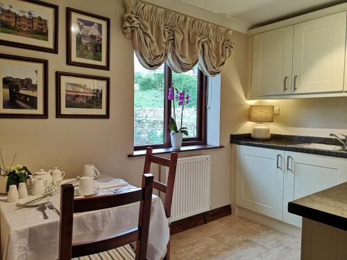 a kitchen with a table and chairs and a window at Maywalk House B&B in Eyam
