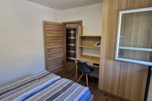 1 dormitorio con cama, escritorio y silla en Mountain views apartment, en Bohinj
