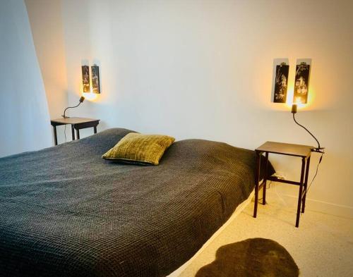 1 dormitorio con 1 cama con 2 lámparas y 1 mesa en Les Sardinières, en Le Relecq-Kerhuon