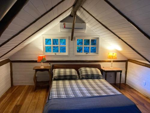 Bett in einem Zimmer mit 2 Tischen und 2 Lampen in der Unterkunft Rain Forest Paradise in Rio de Janeiro
