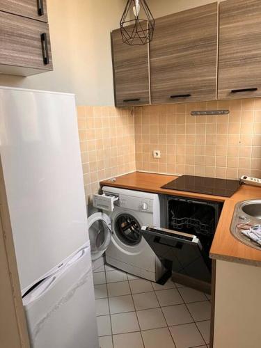 a kitchen with a washing machine and a refrigerator at Centre ville de Nevers. in Nevers