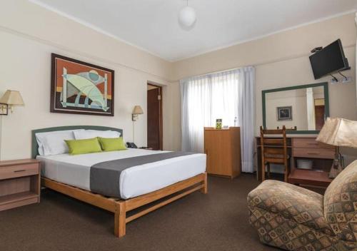 a bedroom with a bed and a desk and a chair at Hotel San Isidro Inn in Lima