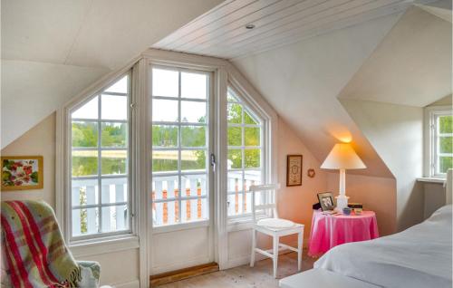 4 Bedroom Beautiful Home In Eskilstuna في Sundby: غرفة نوم مع نافذة كبيرة وسرير وطاولة