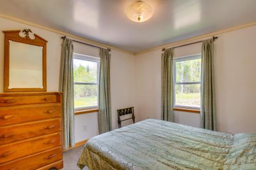 a bedroom with a bed and a dresser and two windows at Beachfront Maine Retreat - Fire Pit, Grill and Canoe in Searsport
