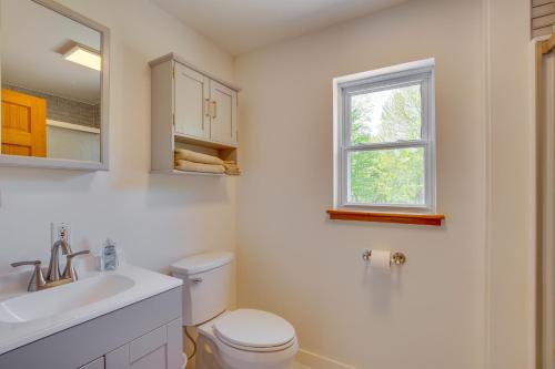 a bathroom with a toilet and a sink and a window at Beachfront Maine Retreat - Fire Pit, Grill and Canoe in Searsport