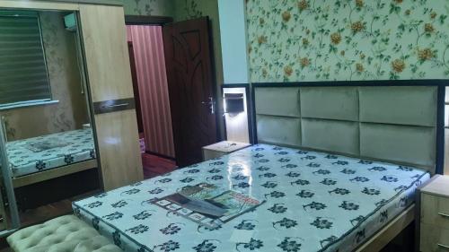 a room with a bed with a table and a mirror at Квартира для 5 человек в Нукусе in Nukus