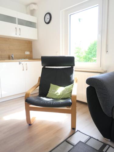 a black chair with a green pillow in a kitchen at Ferienwohnungen und Appartements - Haus Budinger in Alf