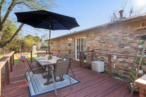 a patio with a table and an umbrella on a deck at Muskogee Guest FavoriteHuge YardCoffee Bar! in Muskogee
