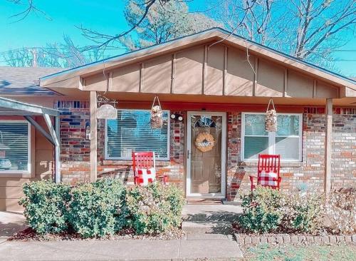 a brick house with two red chairs in front of it at Muskogee Guest FavoriteHuge YardCoffee Bar! in Muskogee