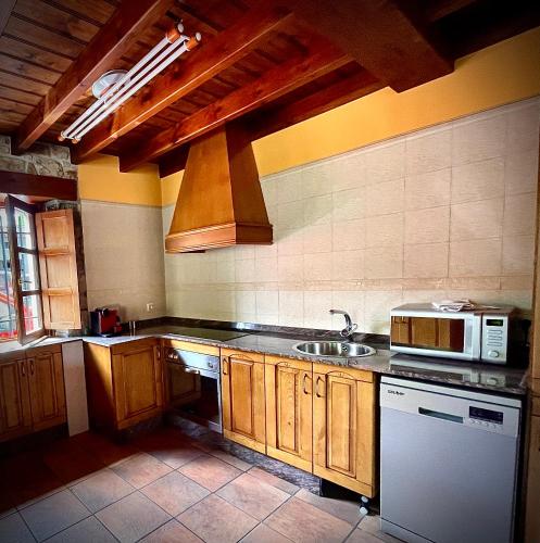 a kitchen with a sink and a microwave at La Bolera - Casa Pandal in Llanes