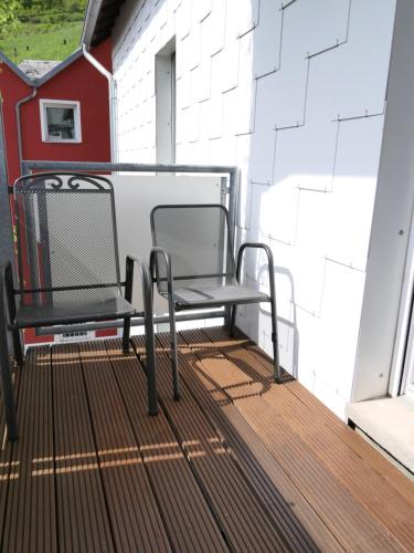 a pair of chairs sitting on a balcony at Ferienwohnungen und Appartements - Haus Budinger in Alf
