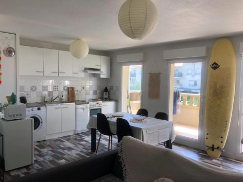 a kitchen and living room with a table and chairs at T2, bord de plage et piscine in Biscarrosse