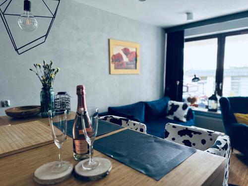 a table with a bottle of champagne and two glasses at Bovis APARTMENT - Gdynia Center Rezydencja Redłowo in Gdynia