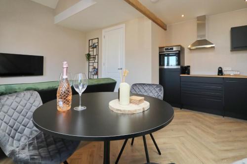 een woonkamer met een tafel met een fles wijn bij appartement-gratis parkeren -bij strand en in het centrum in Noordwijk