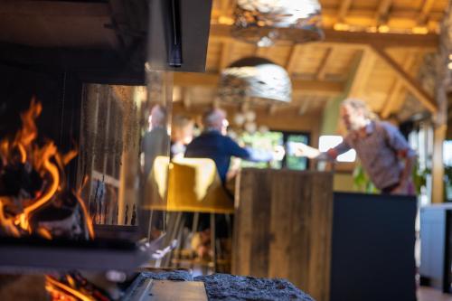 a group of people standing around a bar with a fire at Le 11 des Bouchaux, Gîte d'exception in La Bresse