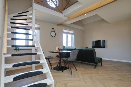 a spiral staircase in a living room with a table at appartement-gratis parkeren -bij strand en in het centrum in Noordwijk