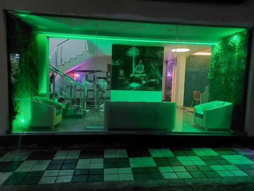 a room with green lights and a table and chairs at Hotel Sai Dakshina Inn & The Fern Restaurant in Shirdi